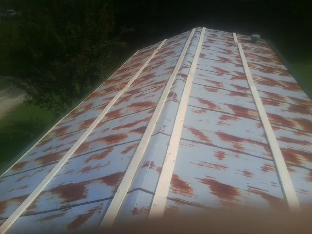 Rusted metal roof panels with new wood purlins before replacement — Storm Damage Roof Repair in Vestal by Roofing Brothers