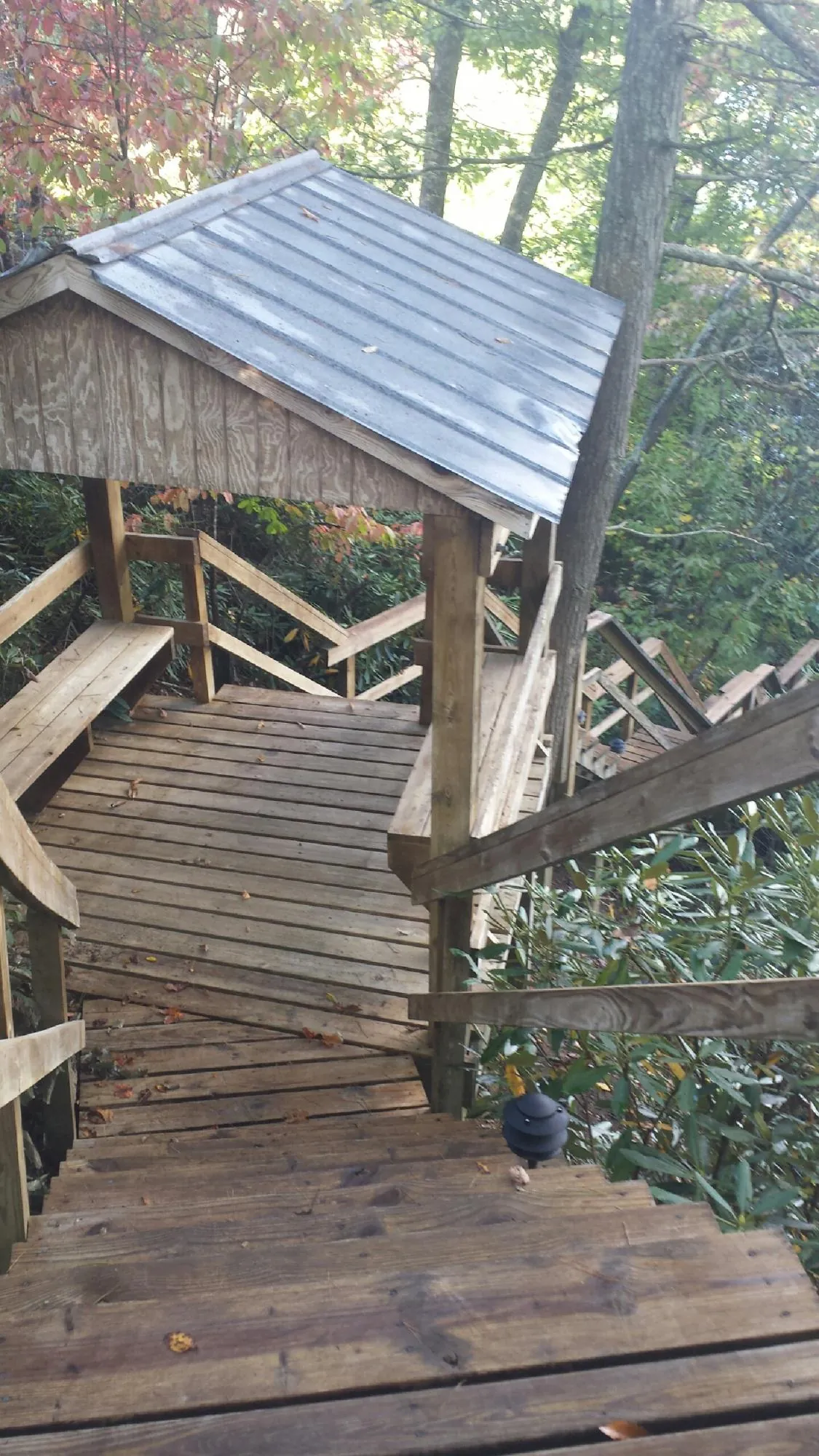 Metal roofed shelter over wooden steps on a wooded walkway — Skylight Repair & Installation work by our crew in Vestal