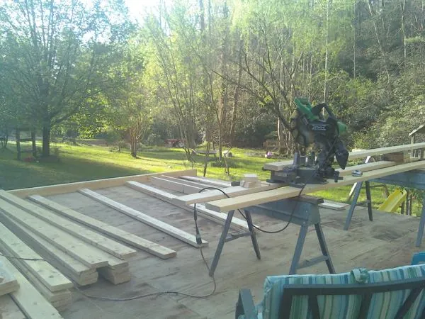 Miter saw and framing lumber on a deck under construction in Vestal