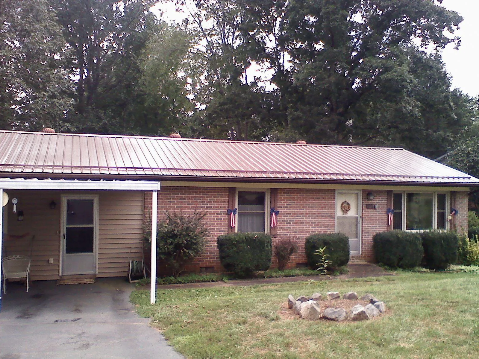 Bronze metal roof and carport on a brick ranch home — Roof Repair work by our crew in Vestal